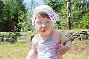 Little baby girl portrait dressing kerchief round her head and swimsuit for swimming, looking at camera