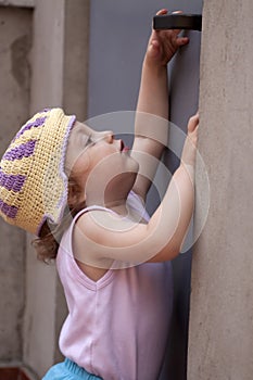 Little baby girl reaching for a door knob
