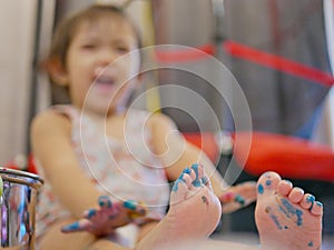 Little baby girl`s toes and toenails being painted, messy, dirty