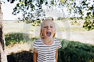 Little baby girl screaming in summer park outdoors