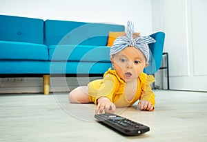 Little baby girl stretch hand reaching tv control