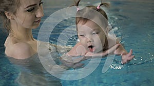 Little baby girl swimming. Learning infant child to swim