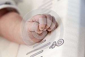 Little baby hand on the measuring table.