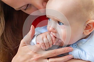 Little baby holding mother& x27;s finger in mouth.