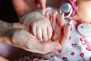 Little baby holding mother`s hand