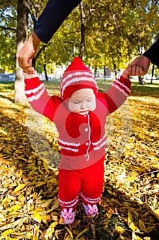 Little baby learning to walk. Mom holding the baby's hands