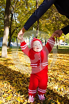 Little baby learning to walk. Mom holding the baby's hands