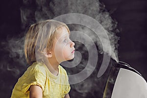 Little baby looks at the humidifier