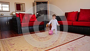 Little baby is playing with a ball. Happy Kid carrying football smiling. boy