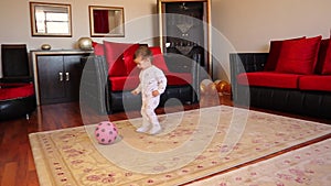 Little baby is playing with a ball. Happy Kid carrying football smiling. boy