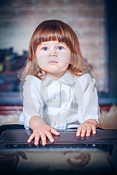 Little baby playing with laptop