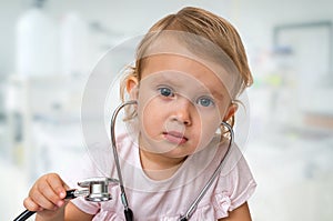 Little baby plays doctor with stethoscope