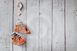 Little baby shoes on a wooden background, concept of the first steps, nostalgia for childhood, design of a children`s room, free s