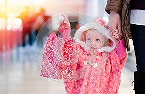 Little baby shopping for gifts in the mall, shopping center .