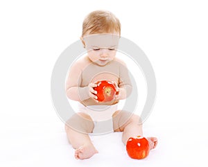 Little baby sitting with reds apples