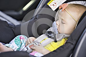Little baby sleeping in a car in a child car seat