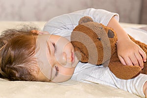 Little baby sleeping hugging a teddy bear. Child girl Caucasian boy sleeping sweetly in bedroom