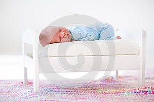 Little baby sleeping in toy bed