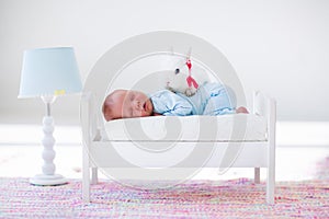 Little baby sleeping in toy bed with pat bunny