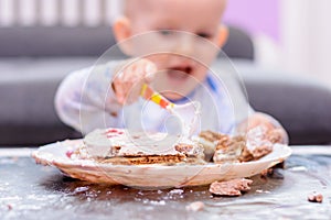 Little baby smash birthday cake with a spoon, happy birthday.