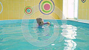 Little baby swimming underwater in the pool