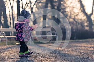 Little baby toddler exploring cold outside world in park