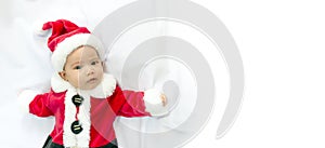 Little baby wearing red Santa Claus costume sleep on white fur carpet. Concept of Christmas and New Year with copy space