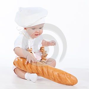 Little baker baby girl with a long loaf and bagels