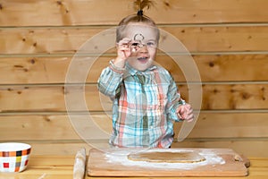 Little baker chef kid at kitchen. Gappy baby child baking cookies. Child cute baby doing homemade bakery in kitchen