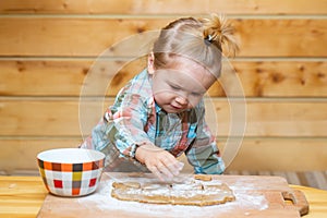 Little baker chef kid at kitchen. Happy baby child baking cookies.