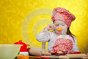 Little baker or cook girl cuts dough for cookies