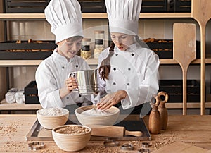Little bakers sieving flour together