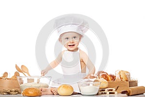 Little bakers in a suit of the cook surprised and smiling in the kitchen. Small kid as a little cook or scullion make pizza in