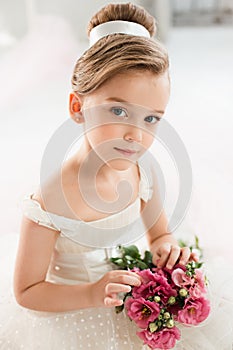 The little balerina in white tutu in class at the ballet school