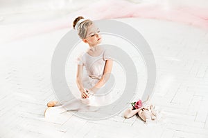 The little balerina in white tutu in class at the ballet school