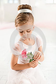 The little balerina in white tutu in class at the ballet school