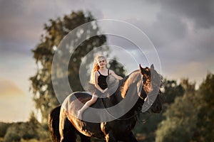 Little ballerina girl with black friesian stallion