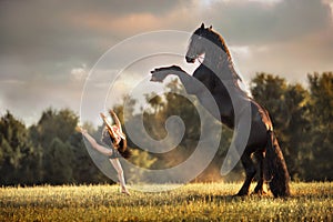 Little ballerina girl with black friesian stallion