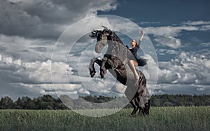 Little ballerina girl with black friesian stallion