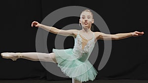 Little ballerina girl child teenager in tutu doing ballet pose position effort balance on one leg exercise upset worry