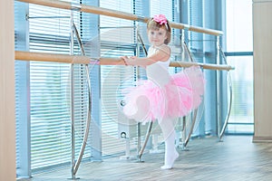 Little ballerina girl in a pink tutu. Adorable child dancing classical ballet in a white studio. Children dance. Kids