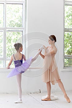 The little ballerina posing at ballet barre with