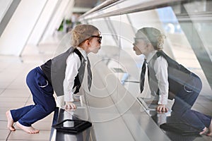 Little barefoot girl sits on floor in gallery near