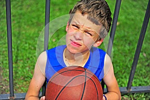 Little basketball player sitting on court