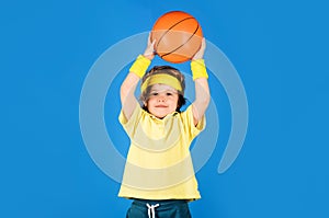 Little basketballer throwing basketball ball. Sportive child boy in uniform playing basketball. Professional sport