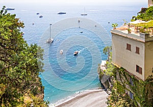 Little beach Spiaggia la Porta with the luxury yachts in Positano, Italy