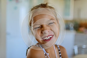 Little beautiful blionde smiling girl poses faces