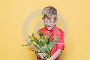 Little beautiful child with pink shirt gives a bouquet of flowers on Women`s Day, Mother`s Day. Birthday. Valentine`s day. Spring.