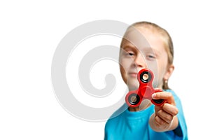 Little beautiful girl in blue t-shirt is playing red spinner in hand