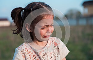 A little beautiful girl cries bitterly from resentment. The child took offense